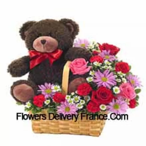 Una hermosa canasta compuesta por rosas rojas y rosadas, claveles rojos y otras flores surtidas de color morado junto con un lindo oso de peluche de 14 pulgadas de altura