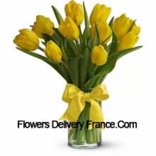 Yellow Tulips With Seasonal Fillers And Leaves In A Glass Vase - Please Note That In Case Of Non-Availability Of Certain Seasonal Flowers The Same Will Be Substituted With Other Flowers Of Same Value