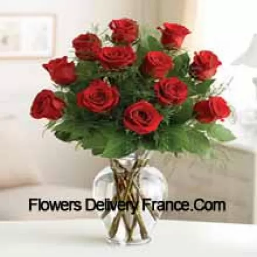 11 Roses rouges avec quelques fougères dans un vase en verre