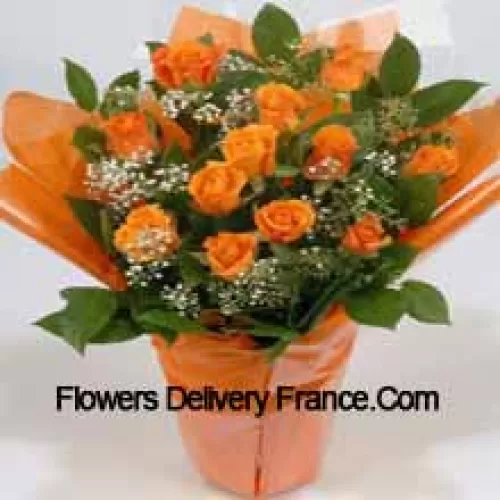 Un bel arrangement de 19 roses orange avec des remplissages saisonniers