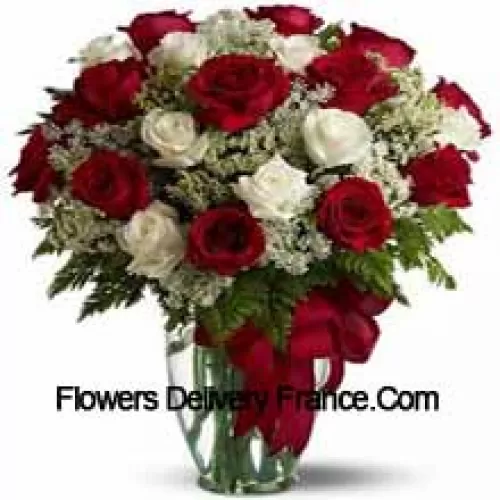 15 Red And 10 White Roses With Some Ferns In A Glass Vase