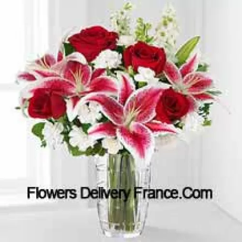 Roses rouges, lys roses avec des fleurs blanches assorties dans un vase en verre