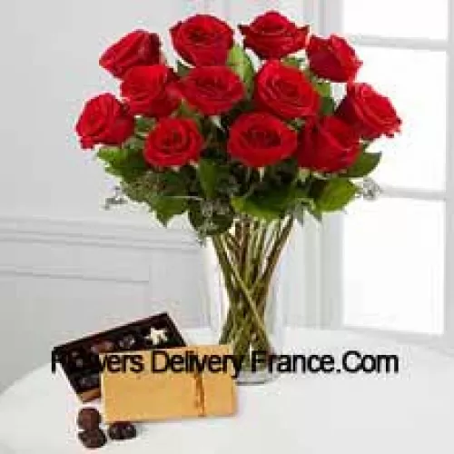 11 Rose Rosse con alcune felci in un vaso e una scatola di cioccolatini Godiva (Ci riserviamo il diritto di sostituire i cioccolatini Godiva con cioccolatini di pari valore in caso di non disponibilità degli stessi. Stock limitato)