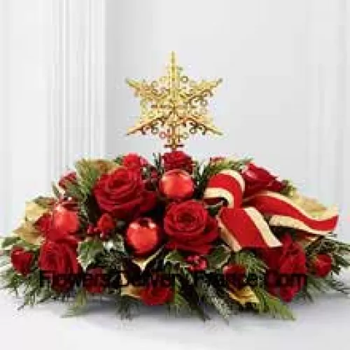 Uma maneira grandiosa e elegante de adicionar beleza às festividades de Natal. Rosas vermelhas e rosas de spray são arranjadas com diversas folhagens de Natal, azevinho variegado, brilhantes bolas vermelhas de Natal e uma fita vermelha com bordas douradas, todas cercando um topper de árvore em forma de estrela dourada para criar um centro de mesa de Natal único e sofisticado. (Por favor, note que nos reservamos o direito de substituir qualquer produto por um produto adequado de valor igual em caso deindisponibilidade de um determinado produto)