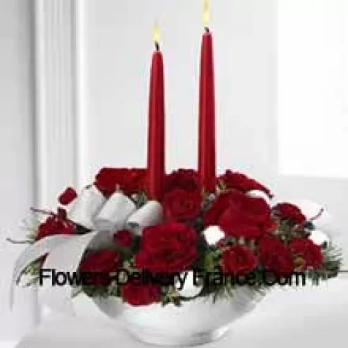 Our Holiday Elegance Centerpiece will add that special spark to their seasonal celebration with its vibrant array of crimson blooms! Red roses, carnations and spray roses sit amongst holiday greens in a posh ceramic silver container adorned with a beautiful silver ribbon accent and two taper candles to bring a holiday glow of warmth and peace to their table. (Please Note That We Reserve The Right To Substitute Any Product With A Suitable Product Of Equal Value In Case Of Non-Availability Of A Certain Product)